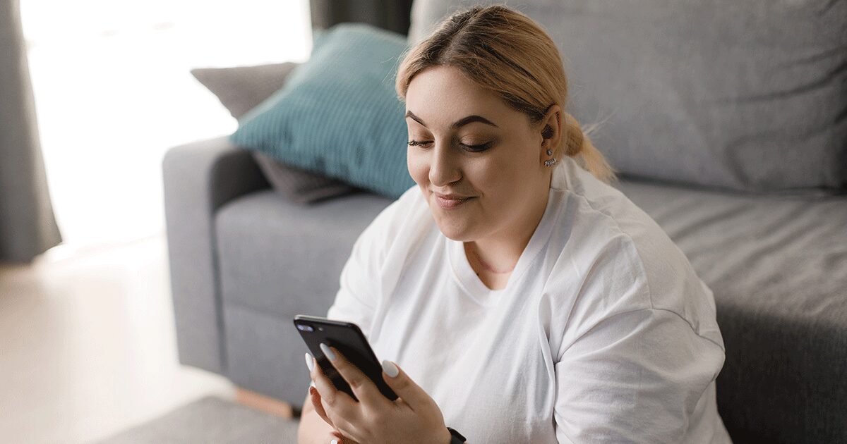 A woman looking on her phone trying to figure out how to deal with the stress of pregnancy during the holidays